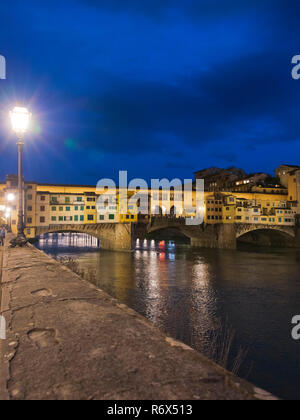 Vertikale Blick auf den Ponte Vecchio in der Nacht in Florenz, Italien, beleuchtet. Stockfoto