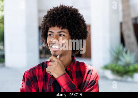 Denken african american hipster Mann mit Afro Frisur in der Stadt Stockfoto