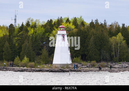 Menschen, die auf der felsigen Küste in der Nähe von grossen Wanne Leuchtturm am Eingang der Großen Wanne Hafen, Tobermory, Ontario, Kanada Stockfoto