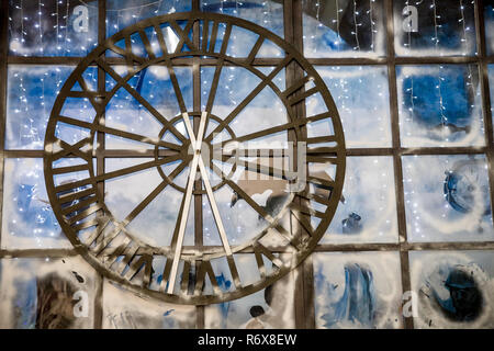 Closeup Bild der geschmückten Innenraum an Wand mit grosse Uhr Hintergrund. Alten rostigen große Straße, an der Wand des Gebäudes, hotel, speichern. Alte Metall Uhr transporent hängen an der Wand. Stockfoto