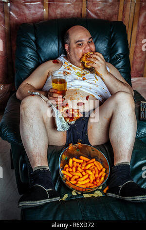 Übergewichtige Menschen essen und fernsehen Stockfoto