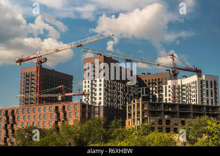 Die Krane arbeiten am Gebäude der ehemaligen industriellen Zone Stockfoto