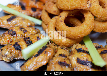 Platte der Flamme gegrillte Hähnchenflügel mit Zwiebelringen und Selleriestangen Zimmer für Kopie Stockfoto