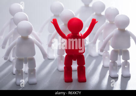 Rote menschliche Figur stehend mit Team in einer Reihe Stockfoto