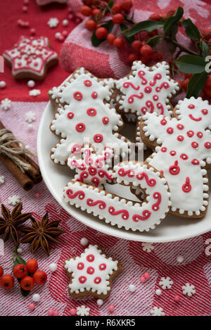 Weihnachtsdekoration auf rotem Stoff Hintergrund. Weihnachtsplätzchen handgefertigte Stockfoto