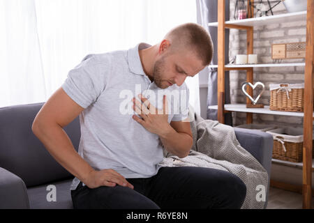 Mann berührte seine Brust während Schmerzen leiden. Stockfoto