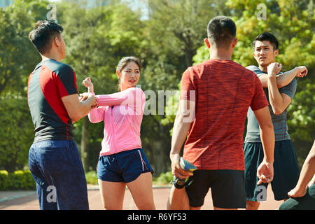 Gruppe von jungen asiatischen Sportler stretching Arme und Beine am Anschluss fertig, für die Ausbildung. Stockfoto