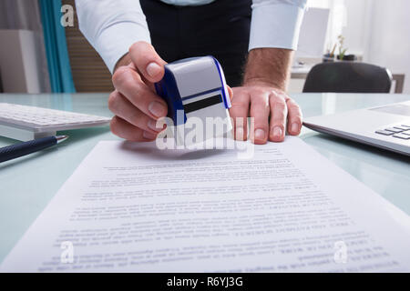 Geschäftsmann Stempeln auf Dokument genehmigt Stockfoto