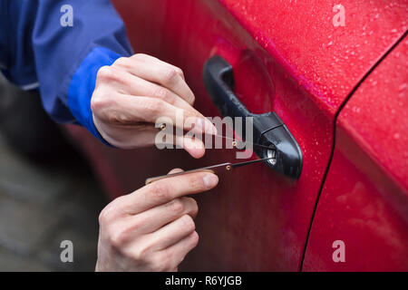 Person Öffnen der Fahrzeugtür mit Lockpicker Stockfoto