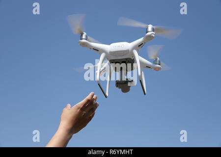 Hand fangen Drohnen im blauen Himmel Hintergrund Stockfoto