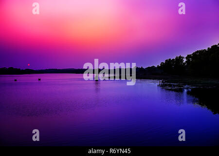 Wasser spiegelt den traumhaften Sonnenuntergang Himmel in der Bank des Flusses. Stockfoto