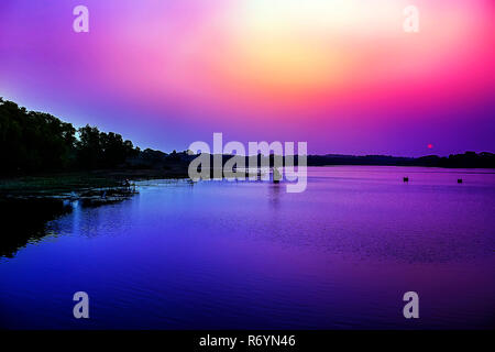 Wasser spiegelt den traumhaften Sonnenuntergang Himmel in der Bank des Flusses. Stockfoto