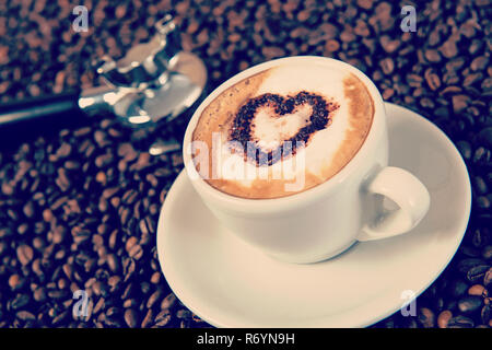 Cappuccino auf eine Menge Kaffee Bohnen Stockfoto