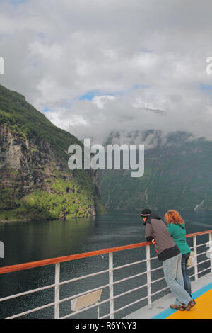 Mann und Frau auf dem Deck von Cruise Liner in Fjord. Hellesylt und Geiranger, Stranda, Norwegen Stockfoto