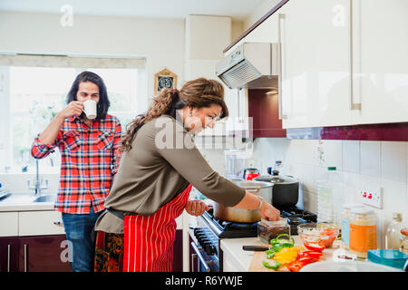 Halten der Mama Unternehmen, während Sie Essen bereitet Stockfoto