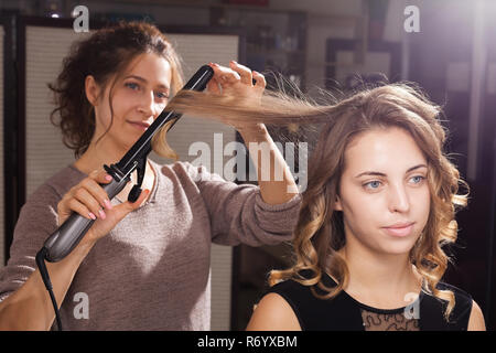 Friseur, eine Frisur mit Locken zu einem Modell Stockfoto