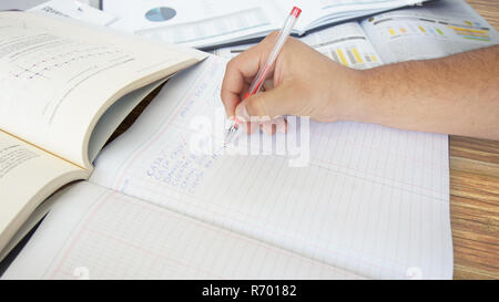 Ansatz zu einer menschlichen Hand schreiben: Banken, FORDERUNGEN AUS LIEFERUNGEN UND LEISTUNGEN, in einem Hauptbuch auf hölzernen Tisch Stockfoto