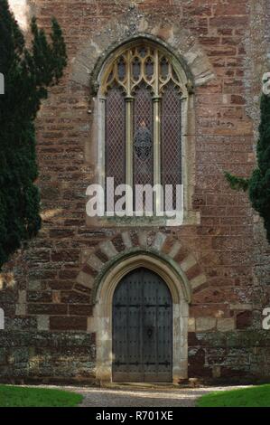 St Clement's Parish Church, Powderham, Devon, Großbritannien. Gotisches Fenster- und Eichenholz Tür im Roten Turm, Mittelalterliche Sakralarchitektur. Stockfoto