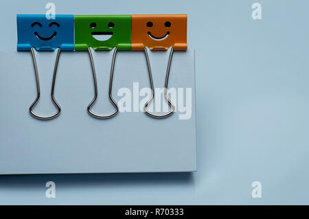 Bunte Binder Clips auf White papers, Glück Charakter. Stockfoto