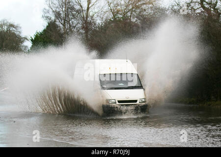 Auto fährt durch tiefes, schnell fließendes Wasser, überflutete Straße in Preston, Lancashire. Dez 2018. Wetter in Großbritannien: Überflutete Straßen nach starkem nächtlichen Regen, was zu schwierigen und gefährlichen Fahrbedingungen führt. Quelle: MediaWorldImages/Alamy Live News Stockfoto