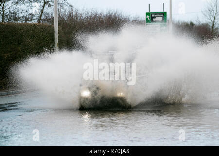 Auto fährt durch tiefes, schnell fließendes Wasser, überflutete Straße in Preston, Lancashire. Dez 2018. Wetter in Großbritannien: Überflutete Straßen nach starkem nächtlichen Regen, was zu schwierigen und gefährlichen Fahrbedingungen führt. Quelle: MediaWorldImages/Alamy Live News Stockfoto