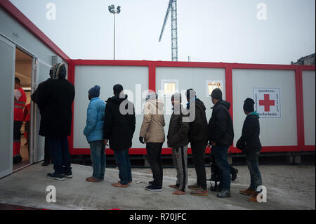 Malaga, Malaga, Spanien. 7 Dez, 2018. Migrantinnen und Migranten sind zu sehen in der Warteschlange zum Eingeben einer humanitären Notsituation Stall nach Ihrer Ankunft im Hafen von Málaga in Spanien Maritime Rescue Service Über 148 Migranten an Bord Jollen auf der Alboran See gerettet und brachte sie nach Malaga Hafen, von wo aus sie durch das Spanische Rote Kreuz unterstützt wurden. Credit: Jesus Merida/SOPA Images/ZUMA Draht/Alamy leben Nachrichten Stockfoto