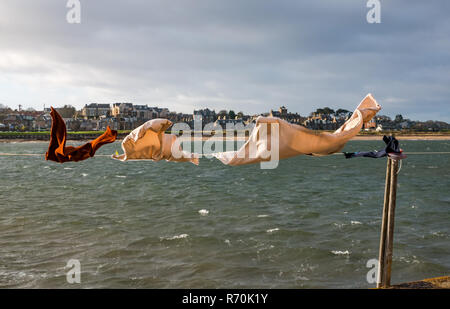 North Berwick, East Lothian, Schottland, Vereinigtes Königreich. Dezember 2018. UK Wetter: Ein heller sonniger, aber sehr windiger Tag in der Küstenstadt mit Wasch hängt an einer Linie weht im Wind in West Bay am Firth of Forth Ufer Stockfoto