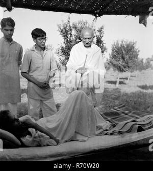 Mahatma Gandhi im Gespräch mit einem Patienten im Sevagram Ashram, Wardha, Maharashtra, Indien, 1941, Altes Vintage 1900er Bild Stockfoto