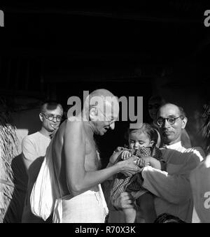 Mahatma Gandhi übergab Nandini, Nichte seines Sekretärs Pyarelal Nayar im Sevagram Ashram, Wardha, Indien, im August 1944, altes Bild aus dem 19. Jahrhundert Stockfoto