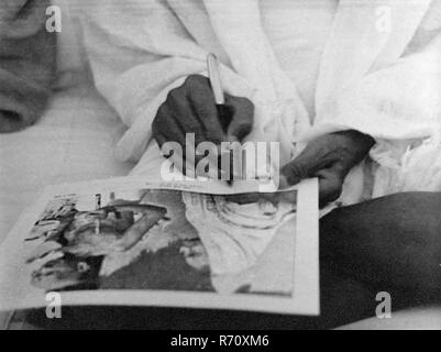 Mahatma Gandhi gibt ein Autogramm auf seinem Foto, Indien, altes Vintage 1900er-Bild Stockfoto