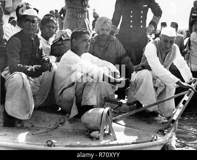 Jawaharlal Nehru, Devdas Gandhi und Ramdas Gandhi mit der Urne mit Mahatma Gandhi Asche auf dem Boot zum Zusammenfluss der Flüsse Ganges, Yamuna und Saraswati, Allahabad, Uttar Pradesh, Indien, 12. Februar 1948, altes Bild des Jahrgangs 1900 Stockfoto