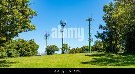 Telekommunikation Masten mit TV-Antenne und Handy Sender in Schönheit Punkt Landschaft mit Bäumen vor blauem Himmel in Australien Stockfoto