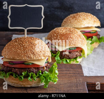 Hamburger mit Fleisch Patty und frisches Gemüse, eine leere Holz- Wegweiser nach oben einstellen Stockfoto