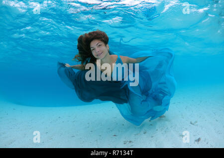 Frau in einem Kleid Schwimmen unter Wasser in den Ozean Stockfoto