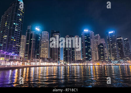 Dubai, Vereinigte Arabische Emirate - Dezember 26, 2017: das Stadtbild von Dubai Marina District in der Nacht. Gebäude mit Licht Reflexion im Wasser. Architektur, Struktur und Design. Reisen und Ferien. Stockfoto