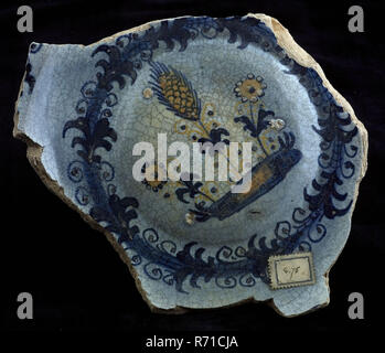 Fragment majolika Teller, Gelb und Blau auf Weiß, Blumen und Ohr von Mais auf Stück Land, Platte Geschirr halter Boden Keramik Steingut finden Glasur, an der Unterseite mit Blei gedeckten gekocht Glasur. Polychrome Bolle Seele der Pfannkuchen Gericht oder Salatteller. In der Schulter in blau Archäologie Rotterdam Dekorieren Essen Aigretterand Bottomvondst Rotterdam 1941. Stockfoto