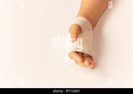 Ältere Frau Hand mit Verband am weißen Tisch mit den Verletzten in den Krankenhäusern. Stockfoto