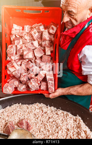 Metzger holding Korb voller gehacktes Schweinefleisch Metzgerei Stockfoto
