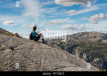 Mittleres Alter Wanderer Frau auf Rock entspannen in Norwegen sitzen Stockfoto