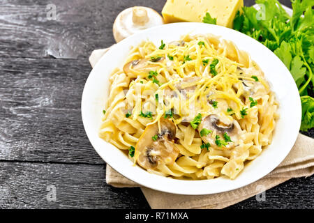 Fusilli mit Pilzen und Sahne in der Platte an Bord Stockfoto