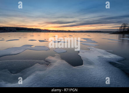 Malerische Winterlandschaft mit gefrorenen See, Sonnenuntergang und schönen Abend licht in Finnland Stockfoto