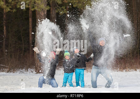 Glückliche Familie Spaziergänge und spielen mit Schnee im Winterwald Stockfoto