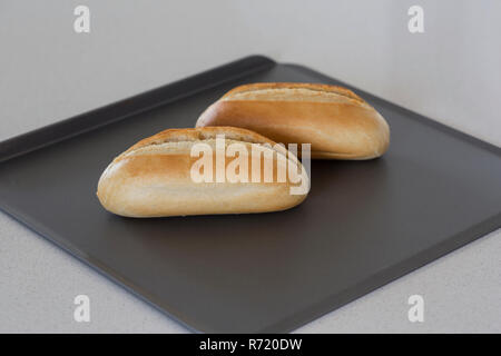 Zwei frisch gebackene Brötchen auf ein Backblech. Stockfoto