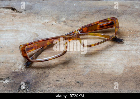 Gebrochene schildpatt Brille auf einer rauhen Holz- Oberfläche Stockfoto