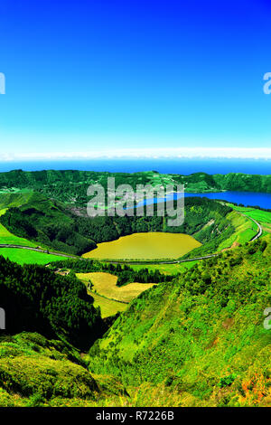 Panoramablick auf die Landschaft mit zwei Kraterseen. Lagoa Santiago im Vordergrund, Lagoa Azul auf der rechten, Dorf Sete Cidades in der Mitte, São Miguel I Stockfoto