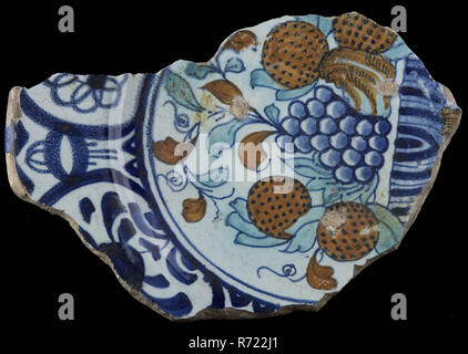 Fragment majolika Teller mit mehrfarbigem Obst, Rim in Wanli Stil, Teller Teller Geschirr halter Boden Keramik Steingut Glasur Glasur Glasur Zinn Blei finden, Hand gedreht Fried glasiert lackiert fried Fragment der Majolika Teller mit Tisch, beladen mit Früchten. Orange Äpfel, Granatäpfel für mögliche andere Obst und Trauben. Polychrome Einrichtung über die Schulter und die Flagge dark blue tape Grenze im Stil der wanli Zeitraum gemalt. Unterseite mit grünlich führen abgedeckt Glasur gekocht auf Pflaumen. Stand ring durchbohrt. Gebrauchsspuren Archäologie Essen servieren servieren Stockfoto