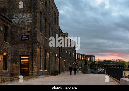 London, England, Großbritannien, 21. November 2018: Die Sonne hinter dem viktorianischen Backsteingebäude Kohle Büro, einst Teil der King's Cross arbeiten und nun einen Shop Stockfoto