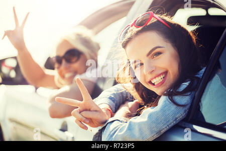 glückliche Mädchen oder Frauen im Auto am Meer Stockfoto