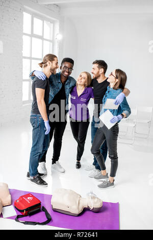 Portrait einer jungen Team von Studenten oder Mitarbeitern gemeinsam mit Lehrer, nachdem der Erste Hilfe Ausbildung in den weißen Klassenzimmer Stockfoto