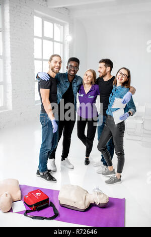 Portrait einer jungen Team von Studenten oder Mitarbeitern gemeinsam mit Lehrer, nachdem der Erste Hilfe Ausbildung in den weißen Klassenzimmer Stockfoto